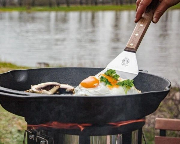 Lac pe fundal si tigaie fonta pe gratar Petromax cu ochi de ou si legume 